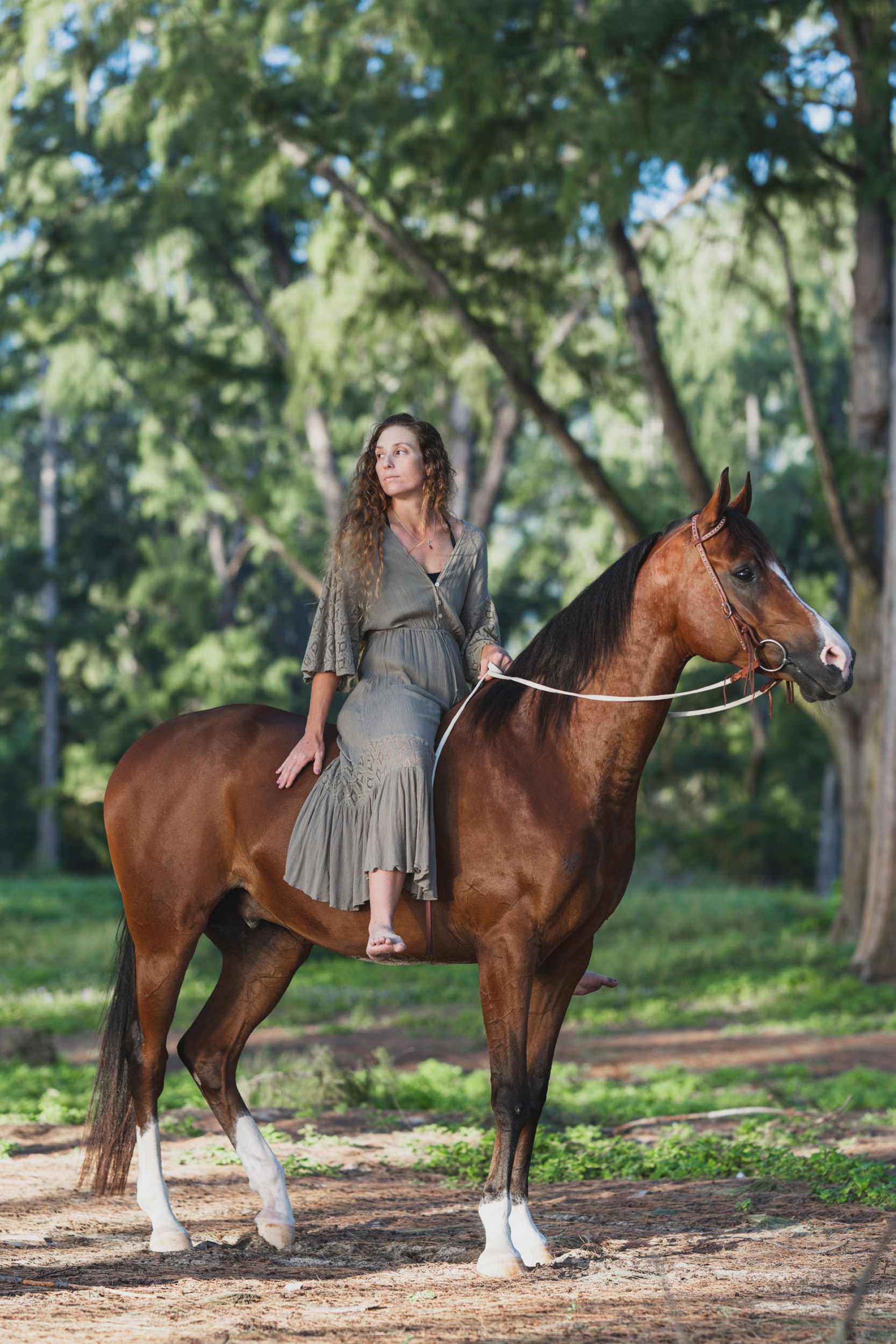 a girl sitting on her horse in the forest